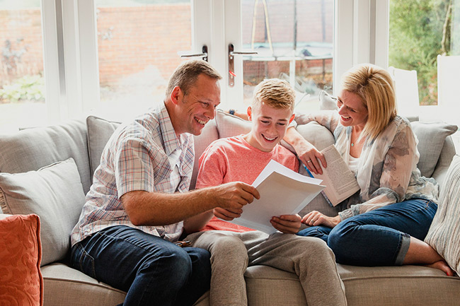 parents with son reading Plan information on sofa