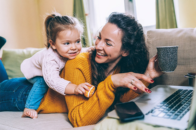 Mum and toddler on the sofa transferring her Junior ISA to Foresters