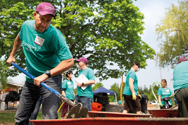 Foresters member at community beautification event digging