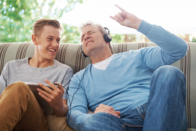 Father listening to music with teenage son who has a Child Trust Fund