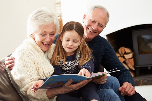 Grandparents reading a book who have a MyPlans gifter account for their daughter