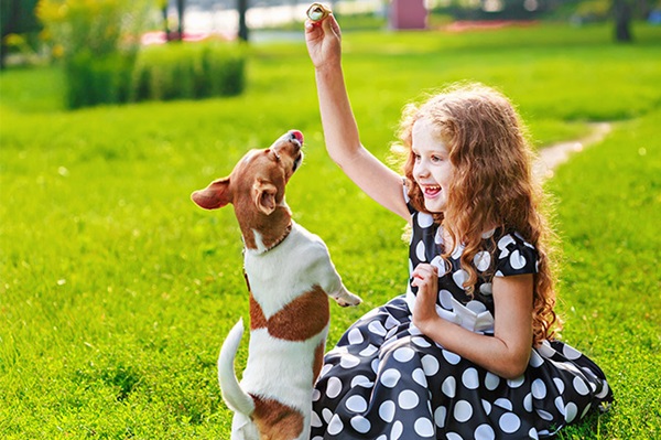 Girl playing with her dog who has a Foresters children's savings Plan