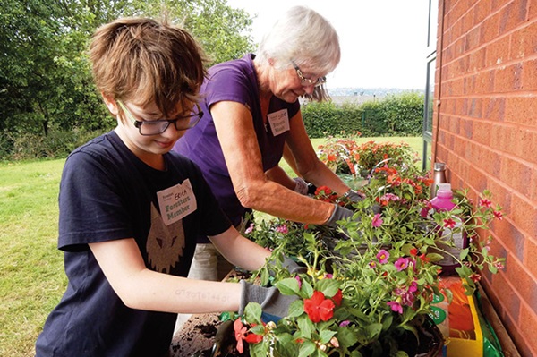 Foresters member and grandson planting flowers at a member event