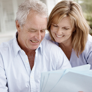 elderly couple reading papers together